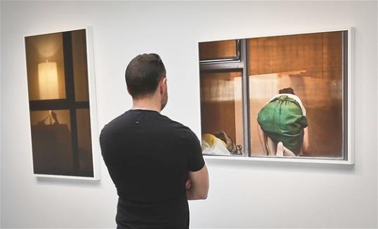 Photo: A visitor views the photography of Arne Svenson at the Julie Saul Gallery in New York. Residents of a New York luxury apartment building are upset over the exhibition by Svenson who secretly made their pictures from his window across the street. (AP Photo/Bebeto Matthews)