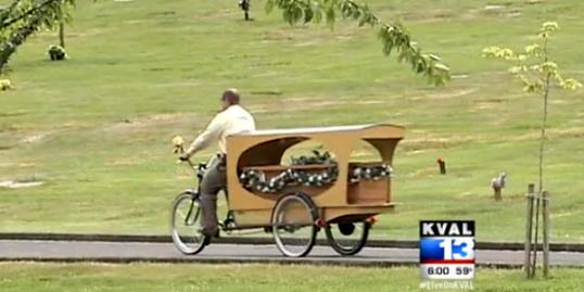 Photo: Still of Wade Lind riding his bicycle hearse (KVAL, http://aka.ms/bicyclehearse) 