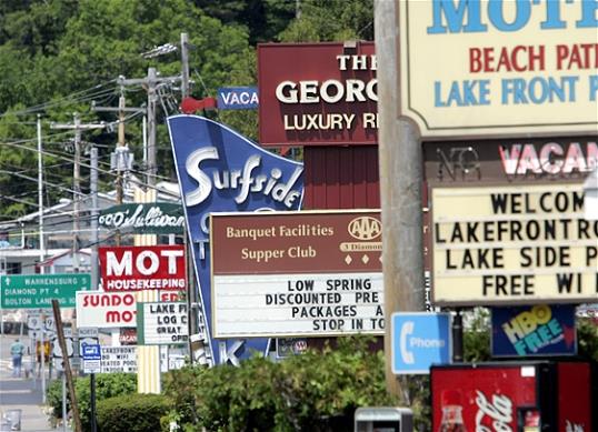 Photo: In this May 2009 file photo, motel signs are seen in Lake George, N.Y. Airlines, hotels and campgrounds are expecting to see more customers in 2013 than in the previous few summers. (AP Photo/Mike Groll, File)