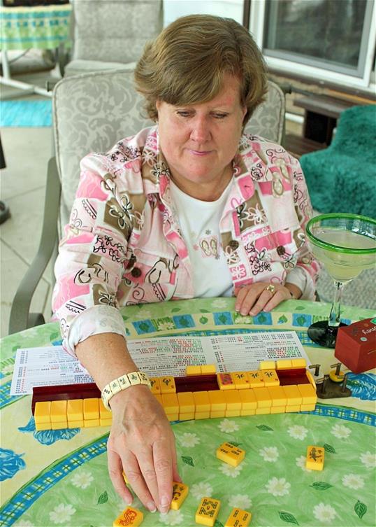 Photo: Judy Palladino handles mahjong pieces during a game night gathering in Mayfield Village, Ohio last month. For the baby boomer generation, getting together to play games is a way to stay active and social. It also can help people stay mentally sharp. (AP Photo/Bonnie Gruttadauria)