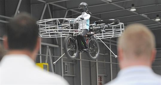Photo: Two men watch the remote-controlled Flying Bike with a test dummy during its presentation in Prague on Wednesday, June 12, 2013. Three Czech companies have teamed up to make a prototype of an electric bicycle that can fly. (AP Photo/CTK, Stanislav Zbynek)