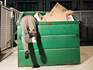 Image: Businessman Searching Through Garbage Container (© Fuse/Getty Images)