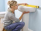 Remodel: Image: Woman Using a Spirit Level on a Sink in a Domestic Bathroom (© Alex Wilson/Digital Vision/Getty Images)