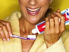 Image: Woman putting toothpaste on toothbrush© Brand X Pictures/Getty Images