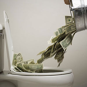 Image: Money into toilet (© RubberBall/SuperStock/SuperStock)