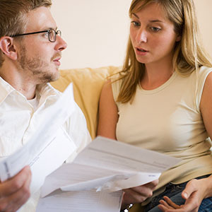 Image: Couple with paperwork (© Christina Kennedy/Brand X/Corbis)