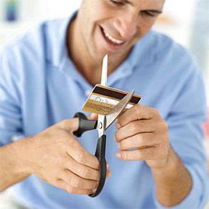 Young man destroying his credit card with a pair of scissors © George Doyle, Stockbyte, Getty Images