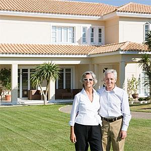 Couple stood outside of villa © Image Source, Image Source, Getty Images