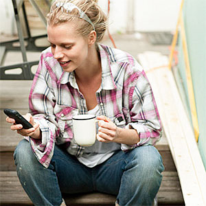 Woman sitting on steps with smartphone © Image Source, Image Source, Getty Images