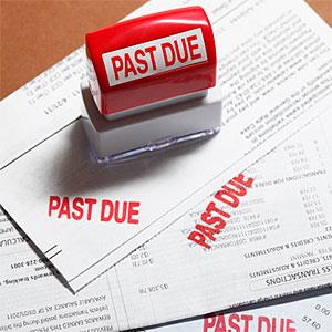 Past due stamp sitting on three bills. © Derek E. Rothchild, Stockbyte, Getty Images