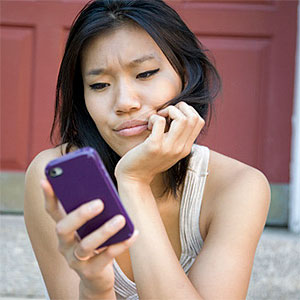 Frustrated woman with mobile device © Jacqueline Veissid, Photodisc, Getty Images