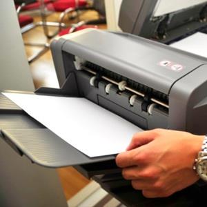 Businessman using printer (© Stephan Zabel/E+/Getty Images)