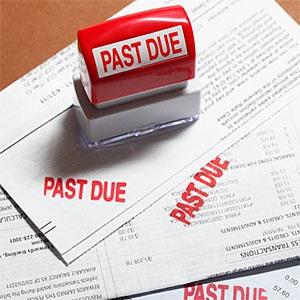 Past due stamp sitting on three bills. © Derek E. Rothchild, Stockbyte, Getty Images