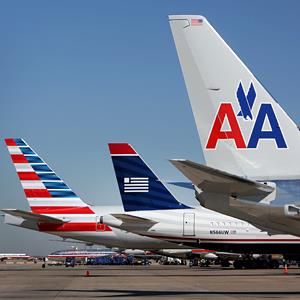 A US Airways airplane sits between two American Airlines jets at Dallas Fort Worth Airport, on February 14, 2013 (© Mike Fuentes/Bloomberg via Getty Images)