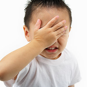 Boy hiding eyes (© Ned Frisk Photography/Corbis)