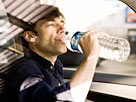Image: Man drinking bottled water while driving (Â© PhotoAlto / SuperStock/SuperStock)