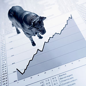 Bull figurine on ascending line graph and list of share prices copyright Adam Gault, OJO Images, Getty Images