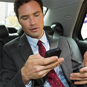 Businessman in car with smartphone copyright Image Source, Image Source, Getty Images