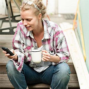 Woman sitting on steps with smartphone copyright Image Source, Image Source, Getty Images