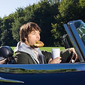 Image, Man eating in car copyright Image Source, Corbis, Corbis