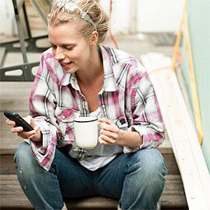 Woman sitting on steps with smartphone Image Source Image Source Getty Images