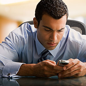  Man using cell phone at desk copyright Jose Luis Pelaez Inc, Blend Images, Getty Images