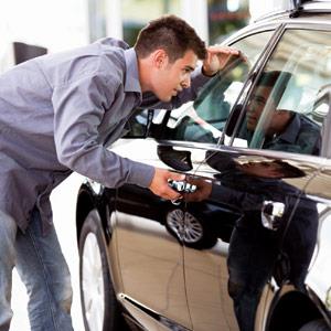 A young man admiring a new car i love images Cultura Getty Images