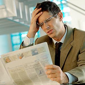 Businessman reading newspaper copyright A. Chederros, ONOKY, Getty Images