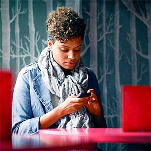 Woman Sitting in a Cafe Texting copyright Stephen Morris, Vetta, Getty Images