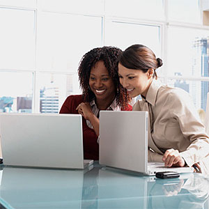 Businesswomen looking at laptops copyright LWA, Larry Williams, Blend Images, Getty Images