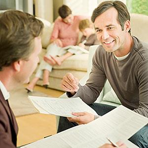 Man meeting with financial adviser in living room copyright Chris Ryan, OJO Images, Getty Images