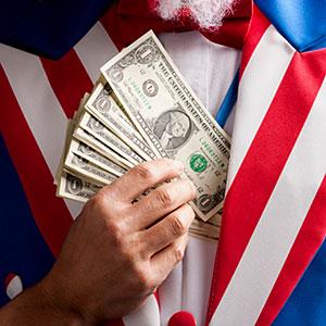 Hand hiding banknotes under vest, studio shot copyright Mike Kemp, Rubberball, Getty Images