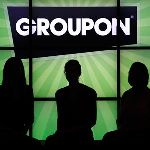 Groupon employees stand in front of the company logo at the company's Chicago office, on Sept. 22, 2011 (© Charles Rex Arbogast/AP)