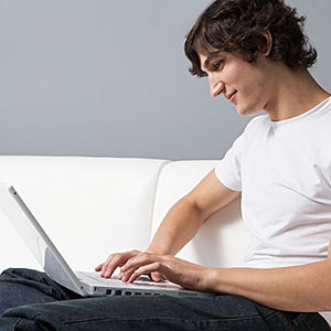 Young man with laptop (© Image Source/SuperStock)