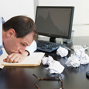 Businessman with face down on desk © Tetra Images, Tetra images, Getty Images