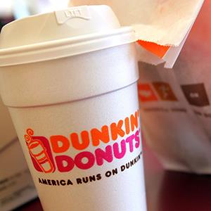 A cup of Dunkin' Donuts coffee and a donut bag (© Tim Boyle/Getty Images)