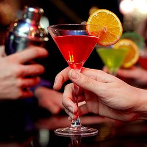 Woman holding martini cocktail at a bar (© mediaphotos/E+/Getty Images)
License: RF