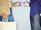 Image: Man handing cash to a woman (© Image Source/Getty Images)