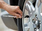 Image: Man checking car tire pressure © Tetra Images/Tetra images/Getty Images