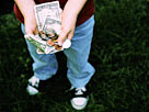 Image: Boy holding allowance money (© Bryan Mullennix/Photodisc/Getty Images)