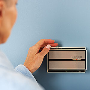 Logo: Woman Adjusting Thermostat (Fuse, Getty Images)