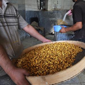 Men go through the pistachio smoking and flavoring process in a small factory in the main bazaar on October 6, 2011 in Tehran, Iran (Kaveh Kazemi/Getty Images)
 