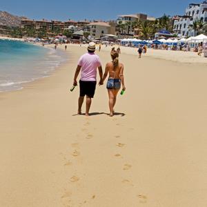 Tourists take a walk on Medano Beach, May 11, 2012, in Cabo San Lucas, Baja California, Mexico (© PAUL J. RICHARDS/AFP/GettyImages)