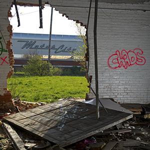 The Motor City Casino and hotel is seen through a hole in the wall of an abandoned building along Grand River Avenue on May 1, 2013 in Detroit, Michigan (© Ann Hermes/The Christian Science Monitor via Getty Images)