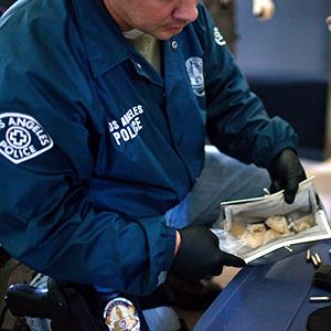 A detective with the Los Angeles Police Department gang unit finds six ounces of crack cocaine inside a woman's purse on April 14, 2010 (© Robert Nickelsberg/Getty Images)