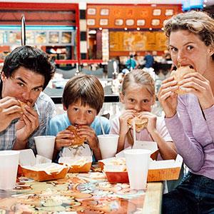 Family eating fast-food burgers (© Bananastock/Jupiterimages)