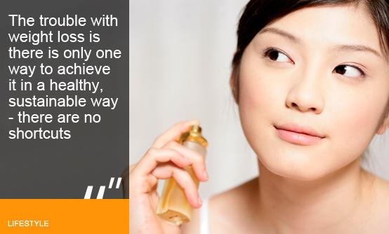 Woman spraying perfume
