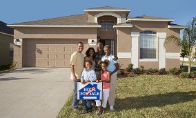 Multi-generation family standing in front of newly-bought home (© Fuse/Getty Images)
