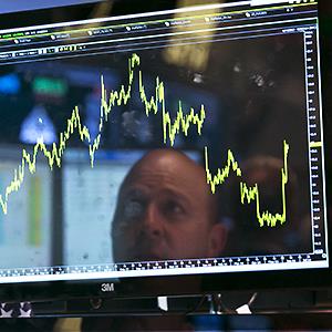 Credit: © Richard Drew/AP
Caption: Specialist Jay Woods is reflected in one of the screens at his post on the floor of the New York Stock Exchange, Wednesday, June 18, 2014