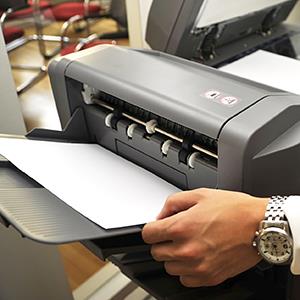 Man using a printer © Stephan Zabel/Getty Images